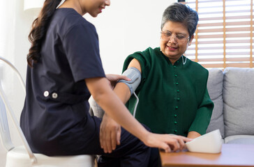 Obraz premium Doctor or nurse using blood pressure gauge with old women patients at Hospitals.