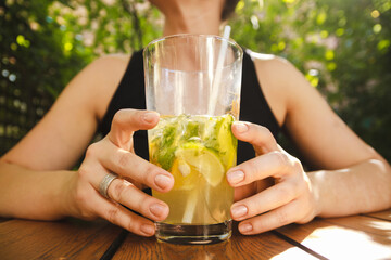 Young girl drinking summer cocktail in a outdoor pub.