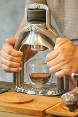 A Barista making a cup of espresso using classic espresso machine, ROK presso