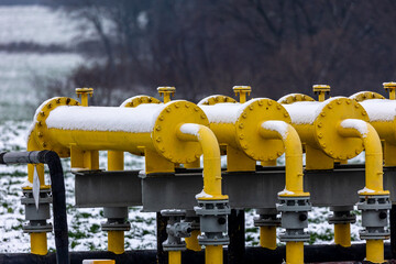 Yellow gas infrastructure elements sticking out of the ground. Winter photo of a snow-covered gas...