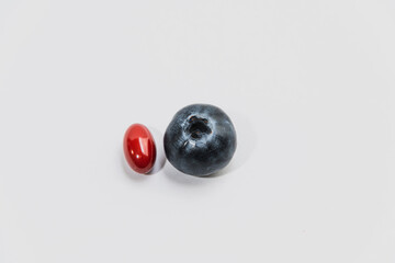 Close-up of blueberry and vitamin capsule