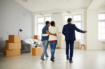 Male realtor or broker show new apartment or flat to couple buyers. Man real estate agent...