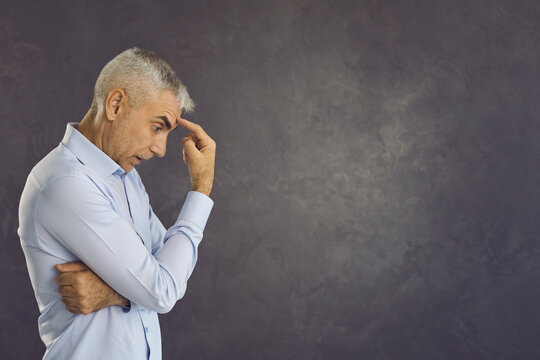 Unhappy pensive middle-aged Caucasian man on black studio think make serious decision solve business problem. Upset thoughtful male plan decide issue feel doubtful frustrated. Copy space.