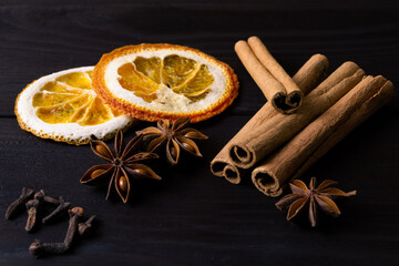Dried orange slice, cinnamon sticks and anise on dark wooden background. Traditional christmas composition