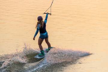 girl training wakeboard on lake 
