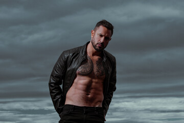 Portrait of handsome man with serious face. Fashion male model with leather jacket.