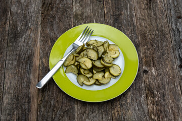 Zucchini Salat auf einem grünen Teller mit einer Gabel