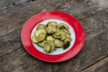 Zucchini Salat auf einem roten Teller auf einem rustikalen hölzernen Untergrund