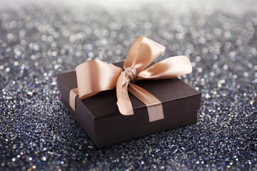 Beautiful gift box on shiny silver glitters. Bokeh effect