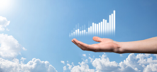 Business man holding tablet and showing holographic graphs and stock market statistics gain profits. Concept of growth planning and business strategy. Display of good economy form digital screen.