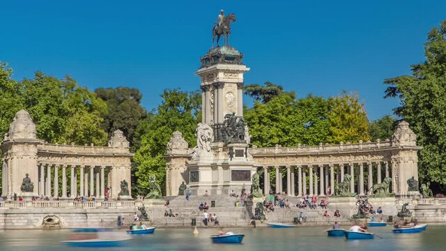 Tourists on boats at Monument to Alfonso XII timelapse hyperlapse in the Park of the Pleasant Retreat in Madrid, Spain