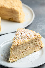 pieces of cake Napoleon on plate, multi layered cake with pastry cream, vertical image. top view
