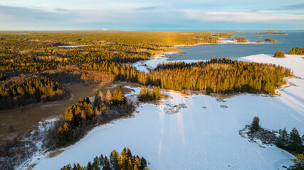 Aerial view of little Swedish village with islands and forests on a Baltic sea coast at winter time. Drone photography - winter in Sweden