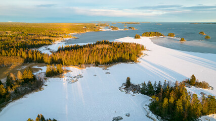 Aerial view of little Swedish village with islands and forests on a Baltic sea coast at winter time. Drone photography - winter in Sweden