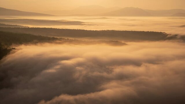 Flowing clouds among mountains. Morning sunrise time lapse