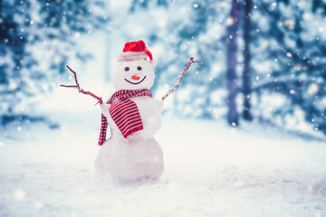 Cheerful snowman with orange scarf and in yellow boots stands upside down in winter