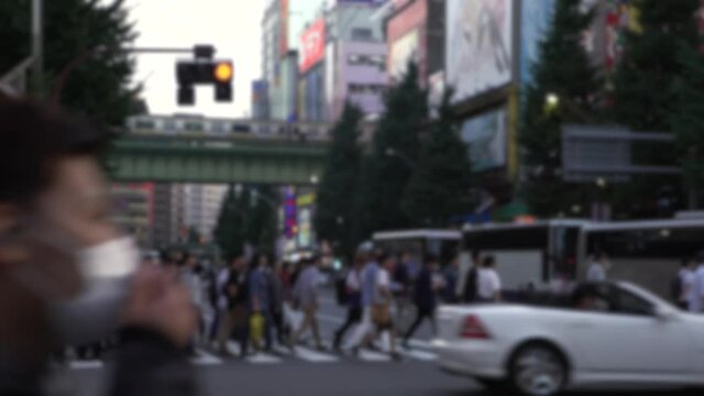 Blurred defocused view of crowd of people crossing the street at Tokyo Akihabara area, known for electronic and anime stores in Japan. Asian pedestrian crosswalk. Japanese shopping