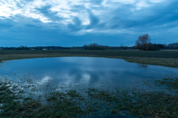 Water in the meadow and the cloudy sky