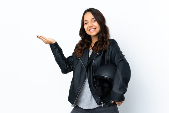 Young woman holding a motorcycle helmet over isolated white background extending hands to the side for inviting to come