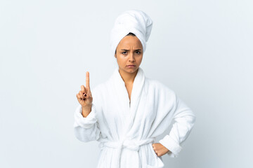 Young woman in bathrobe over isolated white background counting one with serious expression