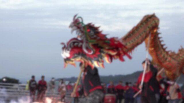 Slow motion and defocused shot of Miaoli Hakka Lantern Festival Dragon Bombing Dance, tradition in Taiwan during Chinese New Year Celebration. Teams dancing dragon to pray for fortune