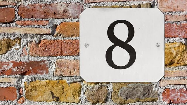 Number 8 street number sign on a brick wall