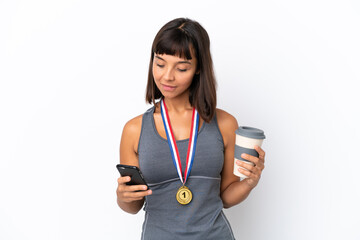 Young mixed race woman with medals isolated on white background holding coffee to take away and a mobile