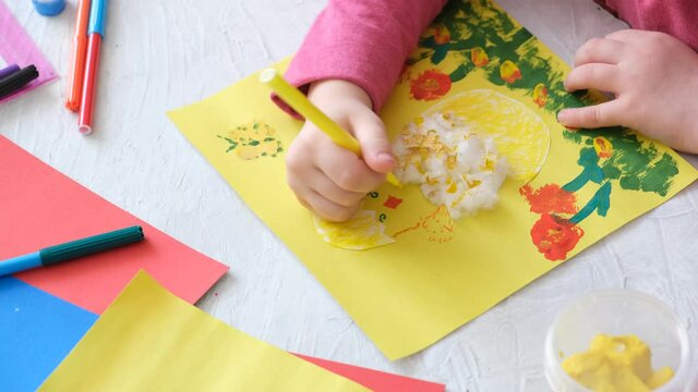Child making card with Easter chick from colorful paper and cotton pad. Handmade. A project of children's creativity, handicrafts, crafts for kids. 