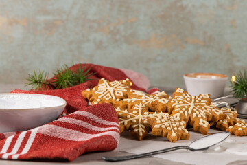 Gingerbread cookies with icing on countertop with festive lights. Christmas cookies snow flakes decorated with sugar frosting. Christmas holiday tradition and advent