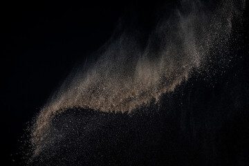 Soil explosion isolated on black background. Abstract cloud of brown ground.