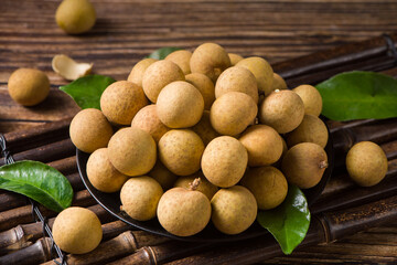 fresh longans in plate on wooden table