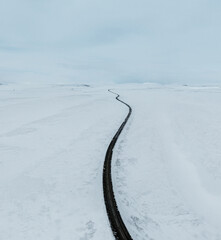 aerial drone view Uphill road landscape in winter at Iceland. Asphalt road with sideways full of...