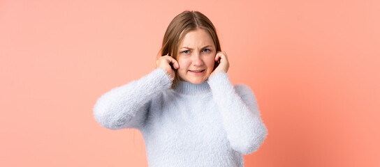 Obraz premium Teenager Ukrainian girl isolated on pink background frustrated and covering ears