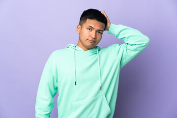 Young Ecuadorian man isolated on purple background with an expression of frustration and not understanding