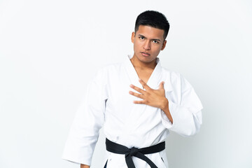 Young Ecuadorian man doing karate isolated on white background surprised and shocked while looking right