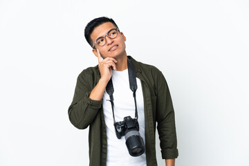 Fototapeta premium Young Ecuadorian photographer isolated on white background thinking an idea while looking up
