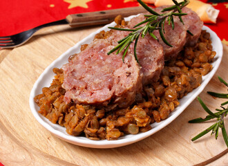Sliced cotechino salami with a side dish of stewed lentils. 