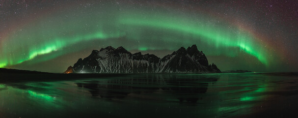 Vestrahorn Stockknes mountain range with aurora borealis and reflection at the beach in Iceland. One of the most beautiful famous nature heritage in Iceland. © Mathias