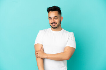 Young caucasian man isolated on blue background laughing