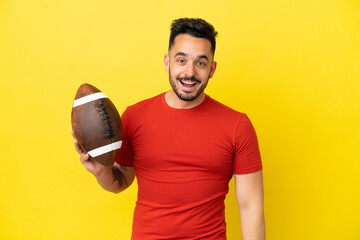 Young Caucasian man playing rugby isolated on yellow background with surprise facial expression