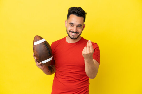 Young Caucasian man playing rugby isolated on yellow background making money gesture