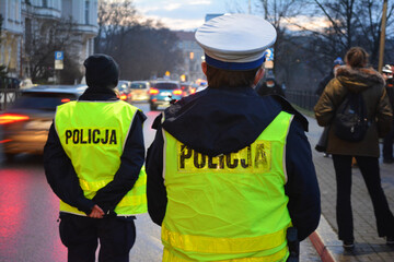 Policjanci ruchu drogowego polskiej policji w mieście podczas kontroli ruchu pojazdów.  - obrazy, fototapety, plakaty