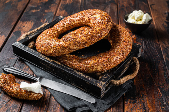 Stack of fresh baked Turkish simit bagel with kaymak. Wooden background. Top view