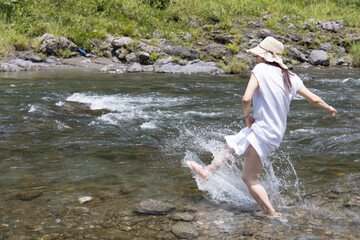 A girl playing with water in the river