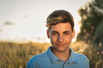 Caucasian teenage boy looking at camera and smiling in the field