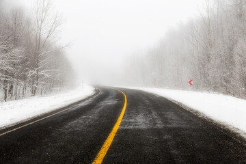 Obraz na płótnie Canvas Snowy and frozen mountain road in winter landscape