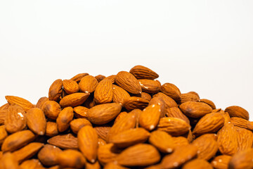 Pile of almonds on the white background. closeup. For vegetarians.Copy space.