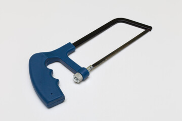 compact hacksaw for metal lies on a white background