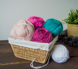 Fototapeta na wymiar colorful woolen balls on dark brown wooden ground for handicrafts with crochet hooks