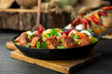 Stew with meat and vegetables in black iron dish. Traditional gourmet goulash in a rustic kitchen